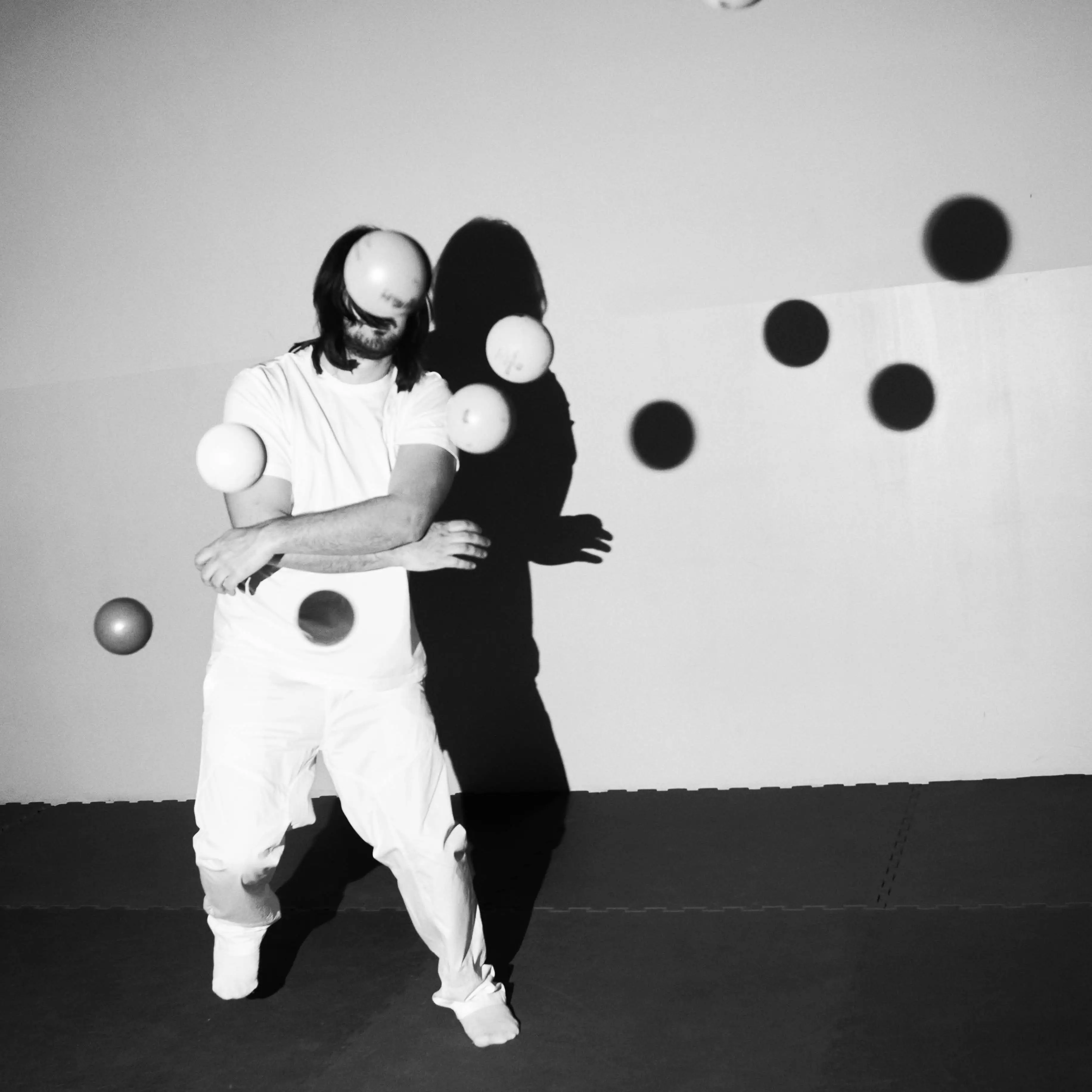 A guy juggling with plastic balls.