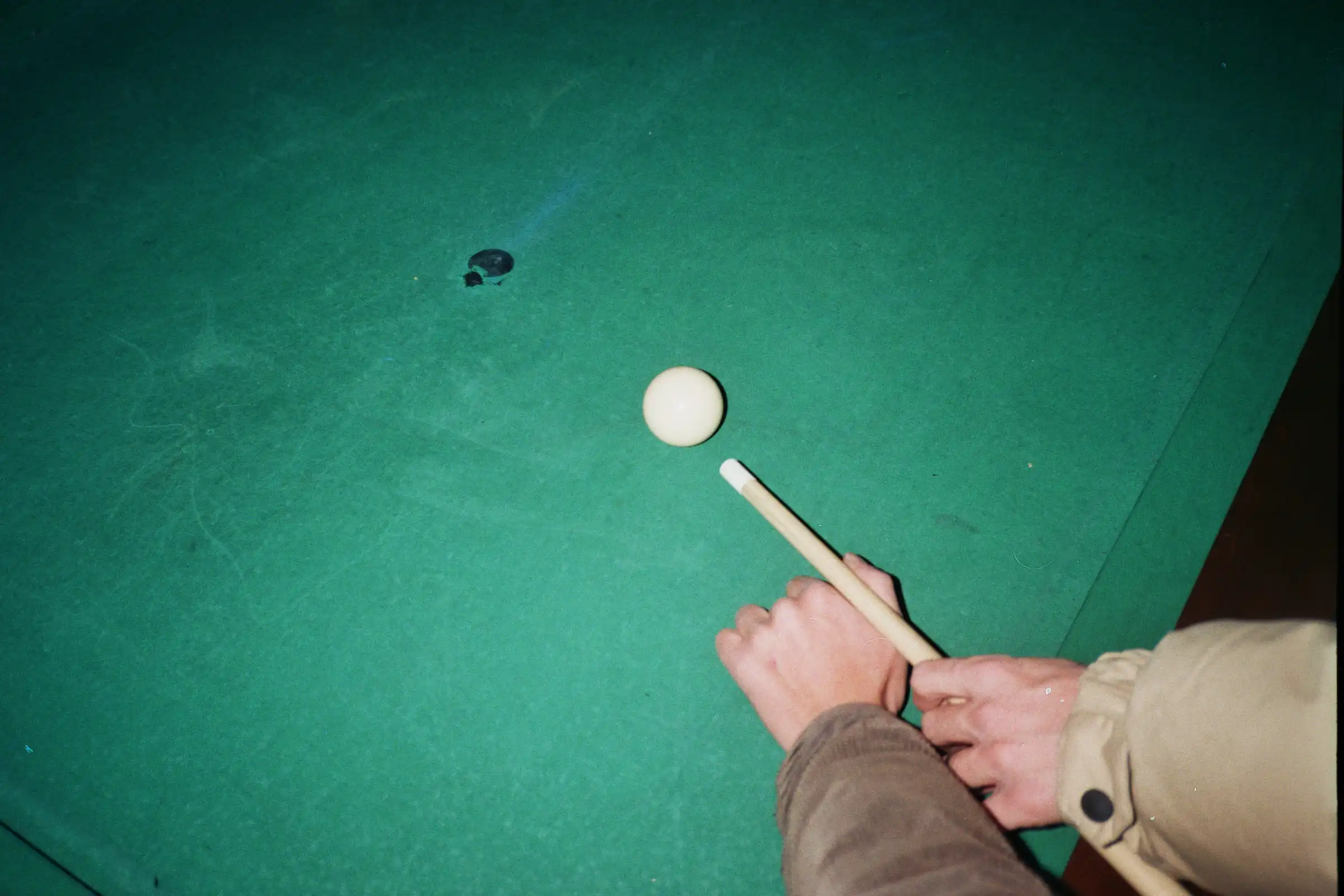 Two hands holding a cue stick.